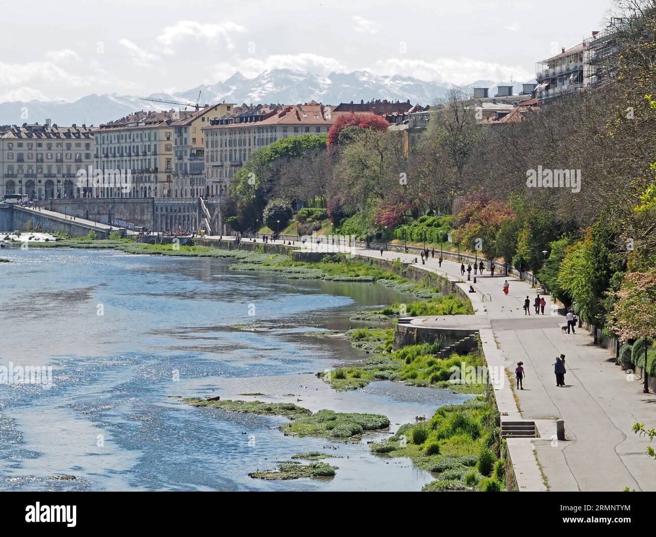 Die Menschen haben die Freizeit am Ufer des Flusses Po, Turin, in der Nähe der Ponte Vittorio Emanuele. Blick auf die Alpen im Hintergrund. Stockfoto
