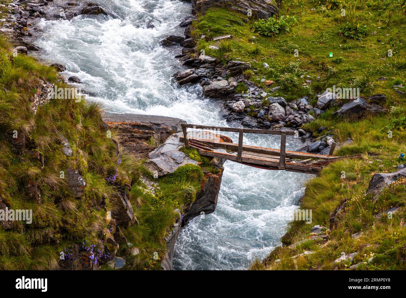 Wanderweg durch Tusheti, Georgia. Die Brücke überquert den Fluss Kvakhidistskali an der Stelle, an der früher eine Natursteinbrücke stand. Übrigens bedeutet die Übersetzung des Flussnamens aus dem Georgischen Stein-Brücke-Wasser Stockfoto