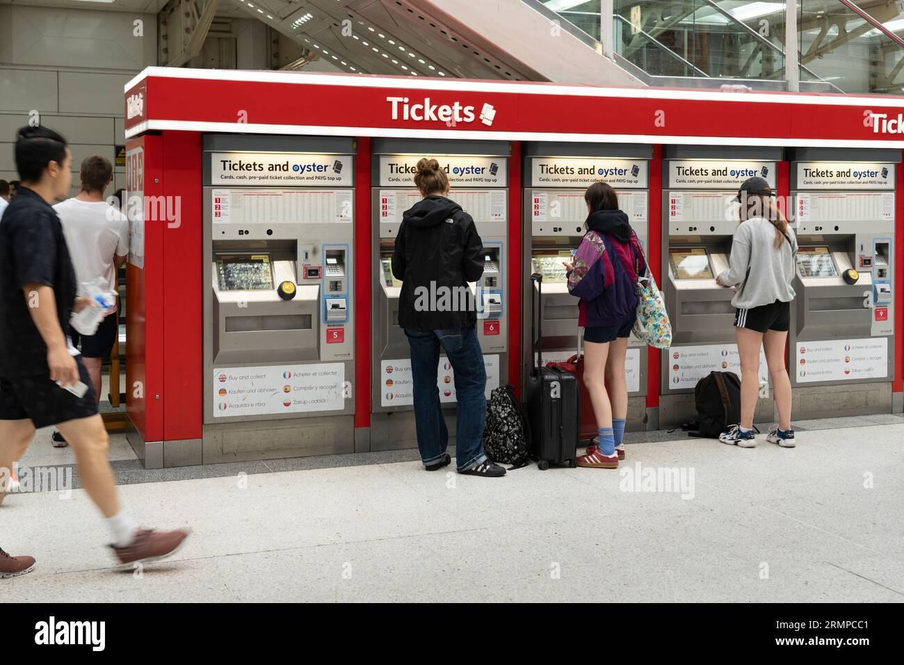 Zugpassagiere, die Tickets an einem Ticketautomat am Bahnhof Liverpool Street, London, kaufen. Thema: Ticketpreise, Preisinflation, Lebenshaltungskosten Stockfoto
