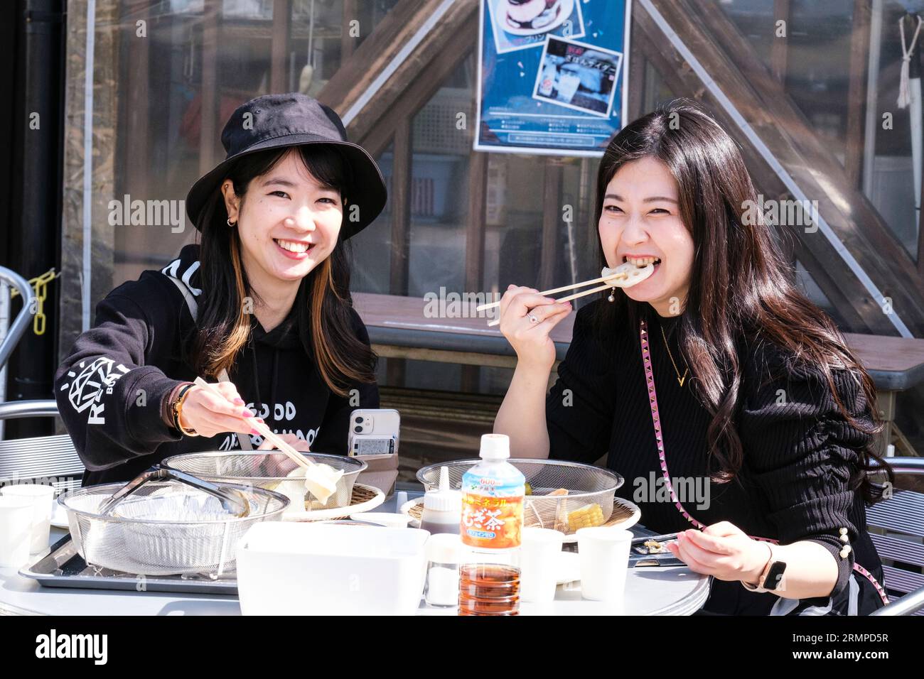Japan, Kyushu, Beppu. Junge Japanische Frauen, die zum Mittagessen Stäbchen benutzen. Stockfoto