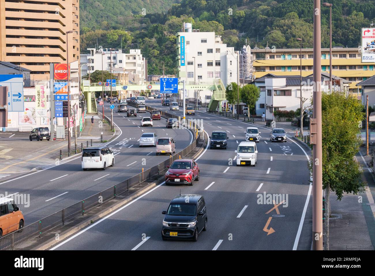 Japan, Kyushu, Beppu. Verkehr am späten Nachmittag auf der National Route 10 durch die Innenstadt von Beppu. Stockfoto