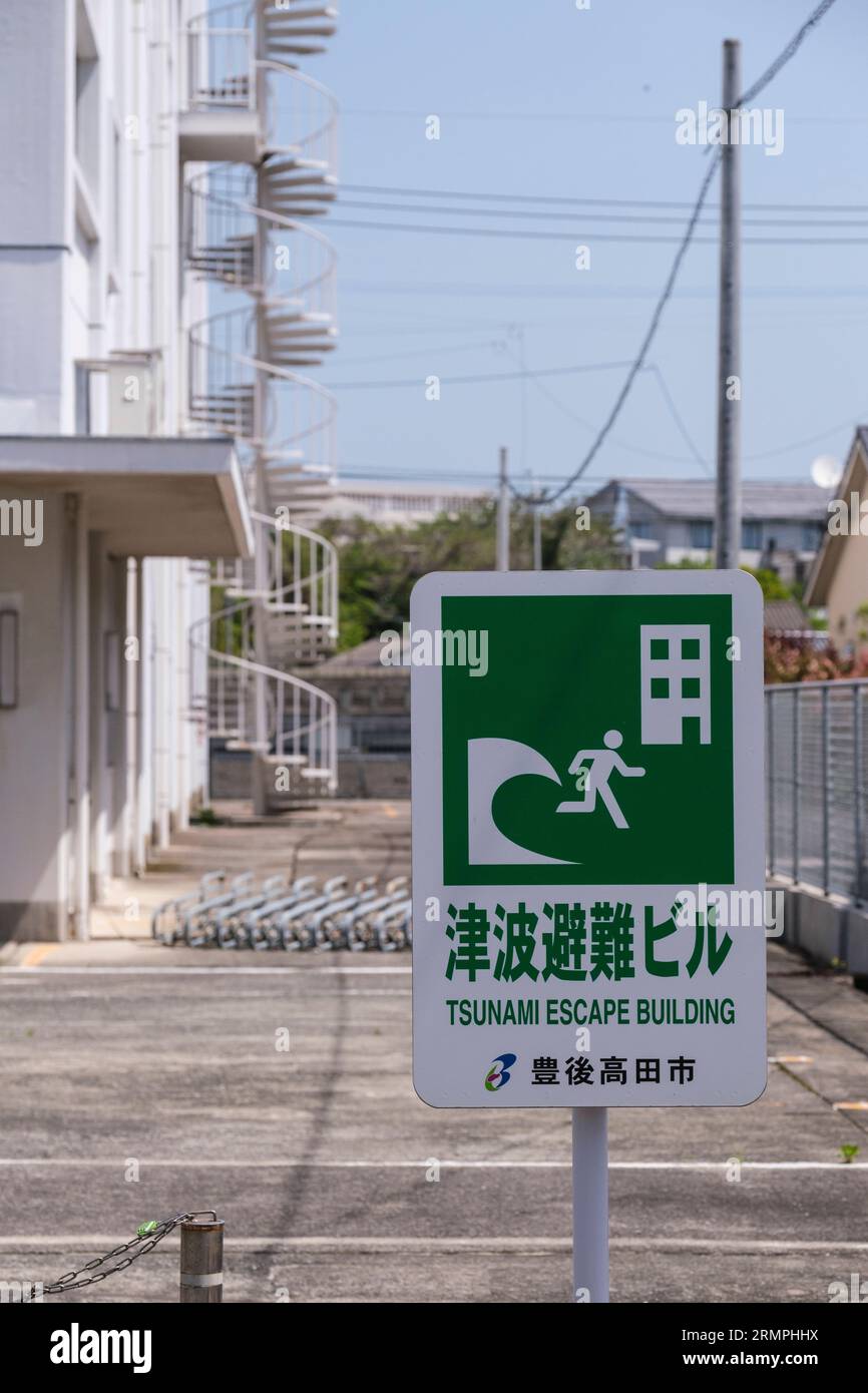 Japan, Kyushu.Bungo-takada Street Scene. Schild Warnung vor Tsunami-Bedrohung, Circular Stairway im Hintergrund bietet schnelle Flucht in höhere Höhen. Stockfoto