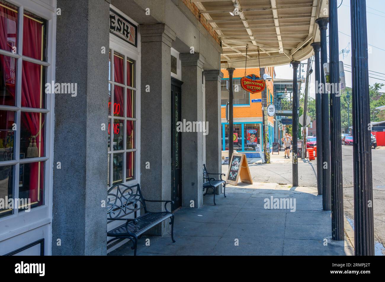NEW ORLEANS, LA, USA - 27. AUGUST 2023: Downtown Tattoo Parlor mit anderen Gebäuden und Touristen im Hintergrund auf der Frenchmen Street Stockfoto