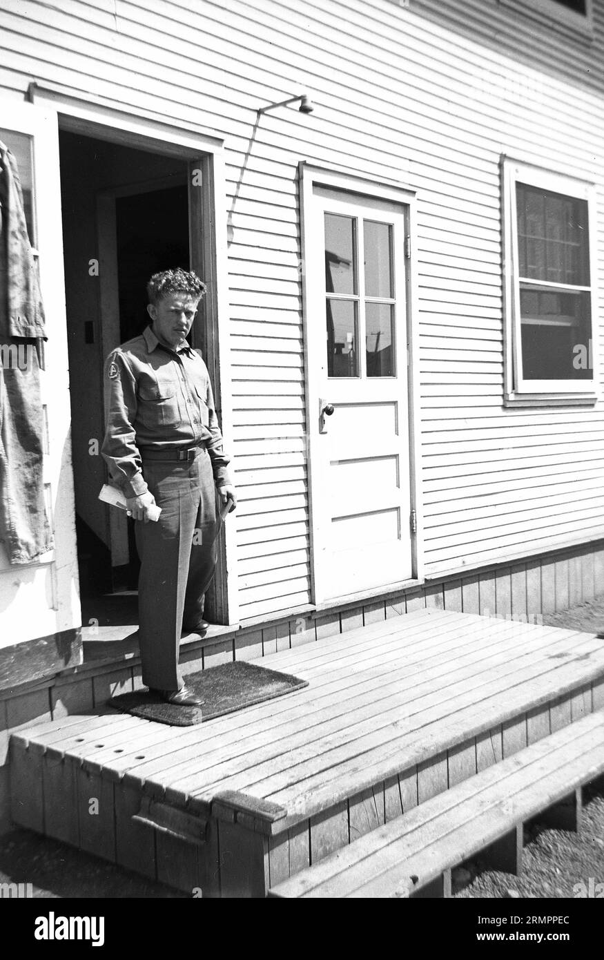 Solider, der in der Tür einer Holzstruktur steht. Mitglieder der 114. Infanteriedivision der US-Armee trainieren im Zweiten Weltkrieg gegen Deutschland in Europa. Stockfoto