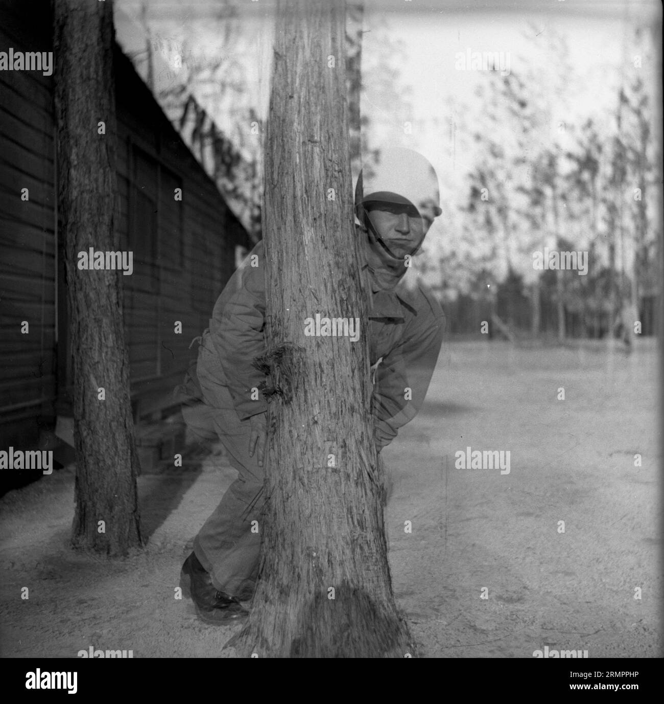 Doppelbelichtungsbild des Soldaten, der mit dem Fotografen Versteck spielt. Mitglieder der 114. Infanteriedivision der US-Armee trainieren im Zweiten Weltkrieg gegen Deutschland in Europa. Stockfoto
