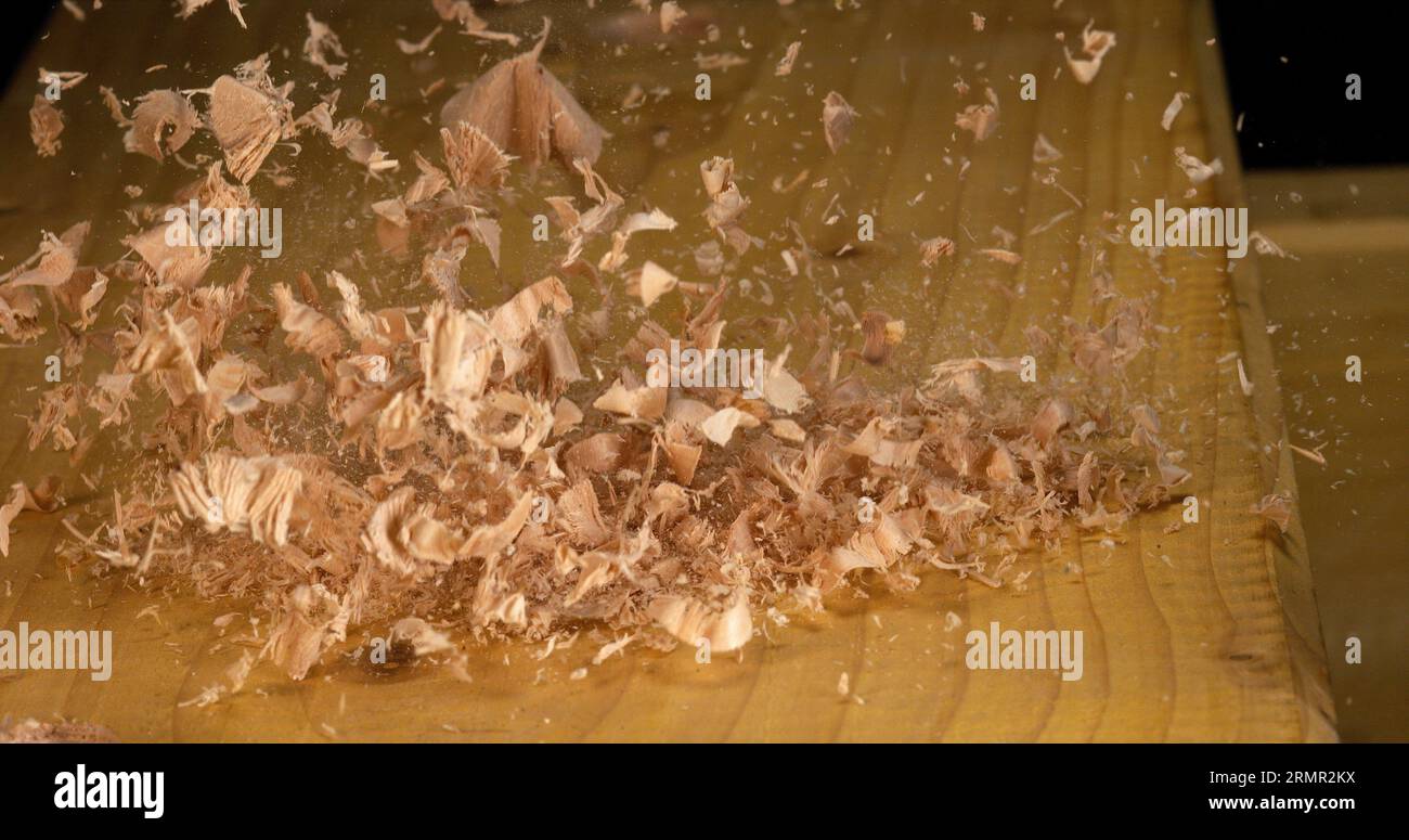 Holzspäne fallen auf ein Brett Stockfoto