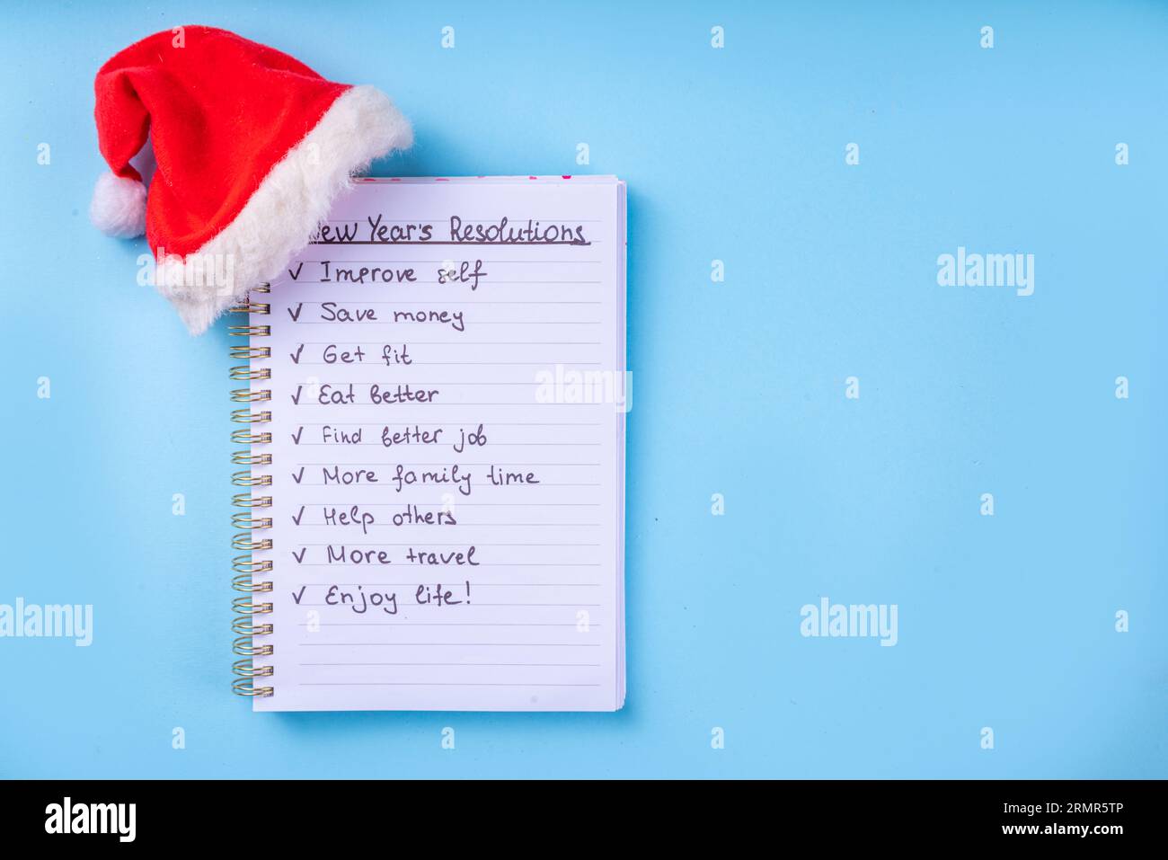 Zielliste für Neujahrsplan auf dem Notizbuch mit Weihnachtsmannmütze, Kaffee Latte oder heiße Schokoladentasse, einfache Neujahrsziele Liste 2023, Planliste für Neujahrsbegi Stockfoto