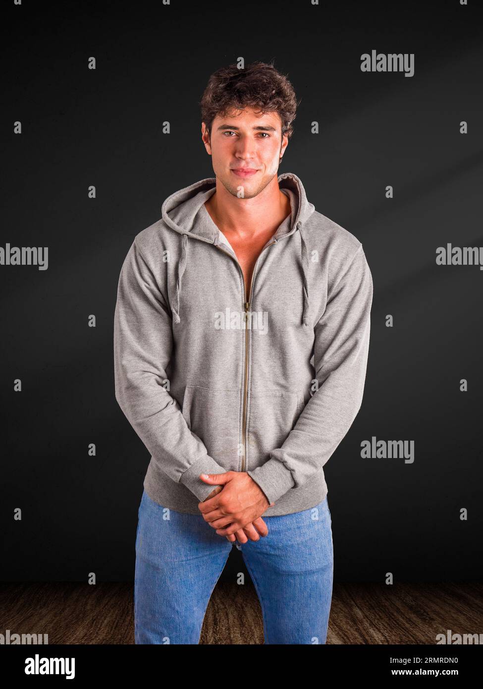 Ein Mann in einem grauen Hoodie posiert für ein Bild Stockfoto