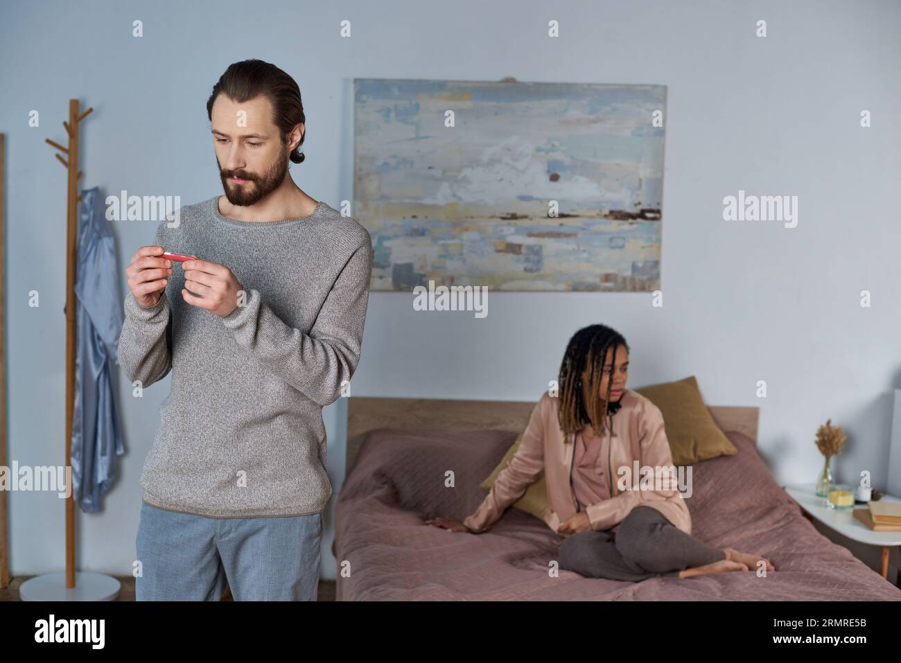 Mann mit Blick auf Schwangerschaftstest, positives Ergebnis, verärgerte afroamerikanische Frau, Abtreibungskonzept Stockfoto