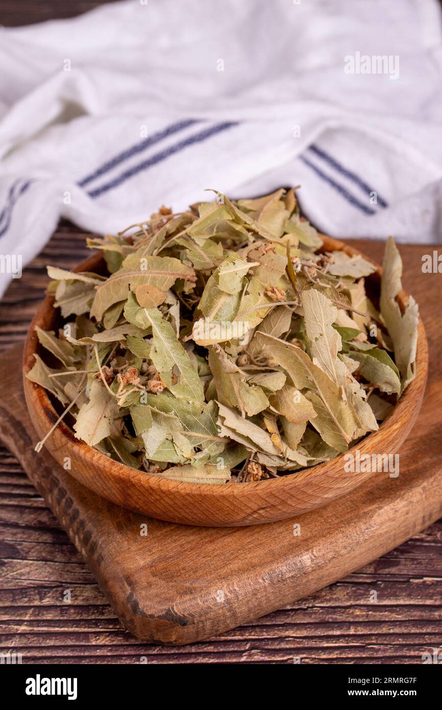 Getrocknete Lindenblüten. Frische Blumen und Lindenblätter in Holzschale. Kräutermedizin Stockfoto