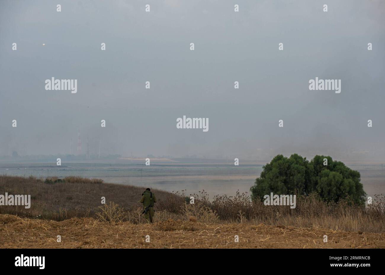 (140728) -- GAZA-GRENZE, 28. Juli 2014 (Xinhua) -- ein israelischer Soldat geht am 28. Juli 2014 auf dem Feld im Süden Israels nahe der Grenze zum Gazastreifen. Israels führende politische und Verteidigungsführung widersetzte sich am Montagabend internationalen Aufrufen zu einem Waffenstillstand im Gazastreifen und beschloss, die massive Offensive dort fortzusetzen, bis das von militanten Gruppen im Gazastreifen ausgehende Risiko neutralisiert wird. (Xinhua/Li Rui) MIDEAST-ISRAEL-GAZA OFFENSIVE-ERWEITERUNG PUBLICATIONxNOTxINxCHN Gaza-Grenze Juli 28 2014 XINHUA zu israelischem Soldat geht auf dem Feld in Südisrael in der Nähe der Grenze zum Gaza Stockfoto