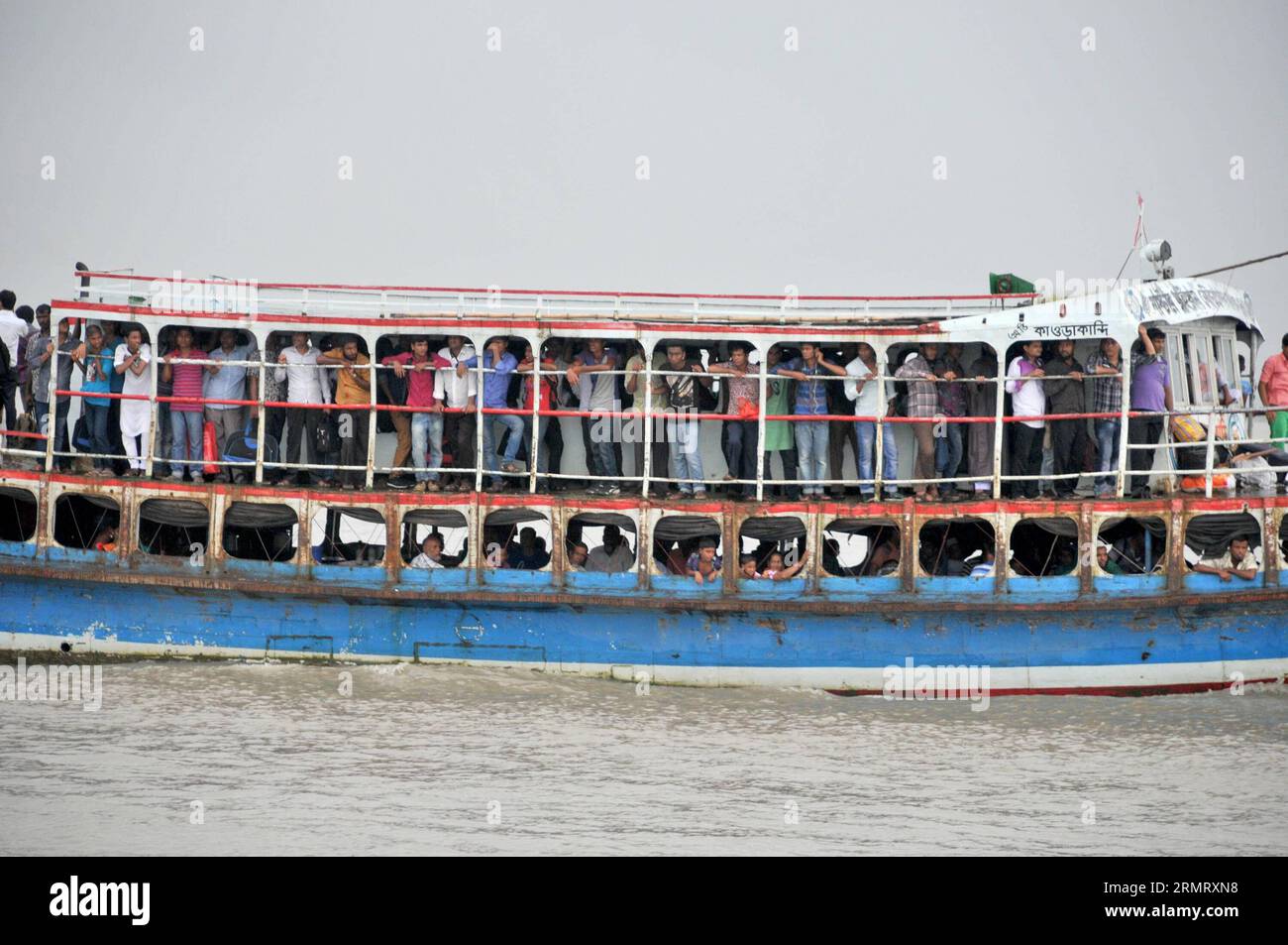 (140806) -- MAWA, 6. August 2014 -- Bangladeshi beobachten die Rettungsaktion während das Rettungsteam zwei Tage nach dem Fährunglück auf dem Padma River im Bezirk Munshiganj, etwa 37 km von der Hauptstadt Dhaka, Bangladesch, 6. August 2014, den Ort im Wasser durchsucht. Die Zahl der Todesopfer der Fähre am Montag in Bangladeschs zentralem Bezirk Munshiganj ist am Mittwochmorgen auf 11 gestiegen, nachdem weitere sieben Leichen weit weg von dem Ort, an dem das Schiff mit etwa 250 Passagieren an Bord sank, abgeholt wurden, sagte die Polizei. ) (lmz) BANGLADESCH-DHAKA-FÄHRE-UNFALL SharifulxIslam PUB Stockfoto