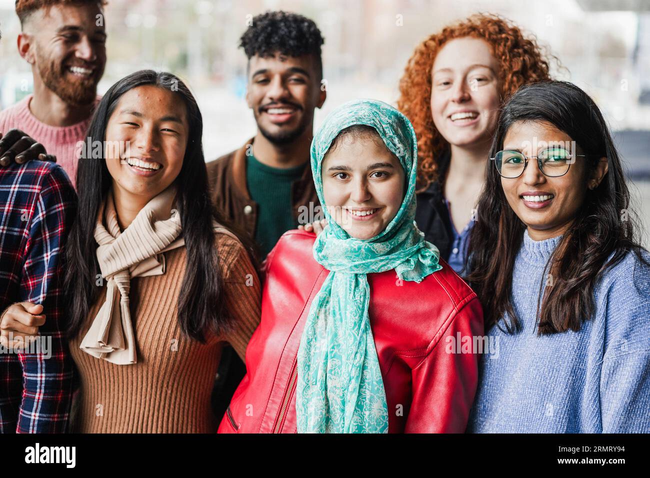 Gruppe junger, multirassischer Freunde, die vor der Kamera im Freien lächeln - Inklusion, Vielfalt und Freundschaftskonzept - Hauptfokus auf muslimisches Mädchengesicht Stockfoto