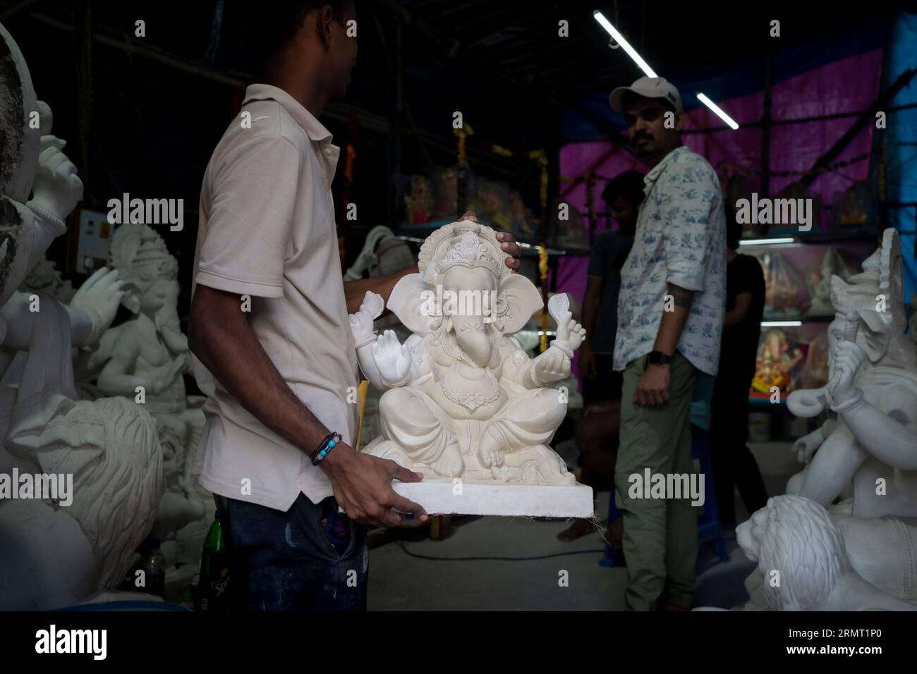 Mumbai, Indien August 29 2023 ein Künstler, der ganesha-Idol in ganesha in der Werkstatt vor dem Ganesha Chaturthi Festival in Maharashtra, Bundesstaat Indien, bewegt Stockfoto
