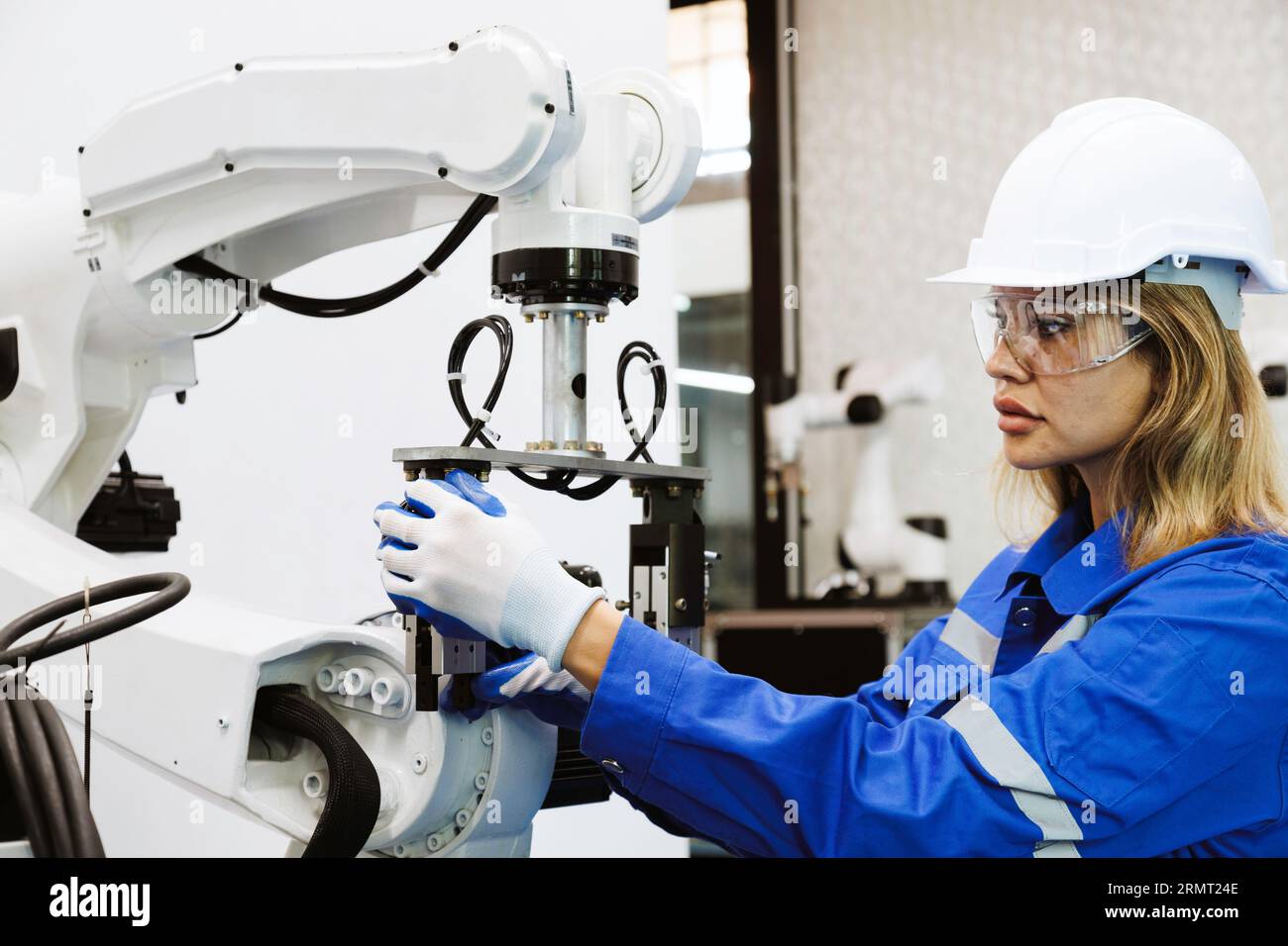 Studentinnen in der Automationstechnik studieren und kontrollieren Roboterarmmaschine in Universitäten oder Fabrikwerkstätten. ki-Robotertechnologie New i Stockfoto
