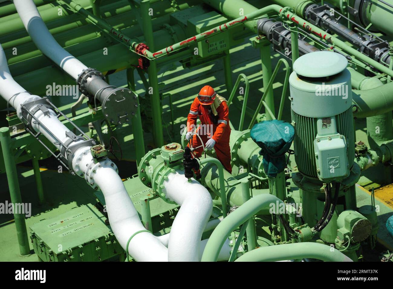 (140812) -- LAMPUNG, 12. August 2014 -- Ein Arbeiter beaufsichtigt die Übertragung von LPG (Liquefied Petroleum Gas) im Besitz von PT. Pertamina, Indonesiens staatliches Energieunternehmen, vom Clipper LPG-Trägerschiff bis zum Star Nusa LPG-Trägerschiff am Semangka-Golf, Provinz Lampung, Indonesien, 12. August 2014. Das Schiff, das als schwimmendes LPG-Lager dient, transportierte 45.000 Tonnen LPG, um auf viele Inseln von Java, Sumatra und Borneo in Indonesien verteilt zu werden. (dzl) INDONESIA-LAMPUNG-LPG TRANSFER-SHIP TO SHIP Zulkarnain PUBLICATIONxNOTxINxCHN 12. August 2014 ein Mitarbeiter beaufsichtigt die Stockfoto