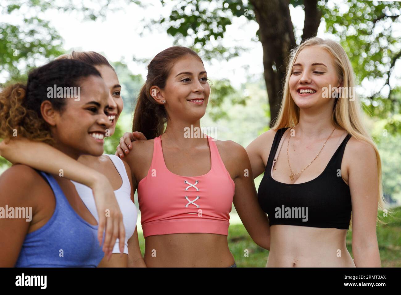 Glückliche lächelnde Freundinnen. Frau redet und hat Spaß im Park nach dem Fitness-Yoga-Kurs Übung am Wochenende Morgen. Stockfoto