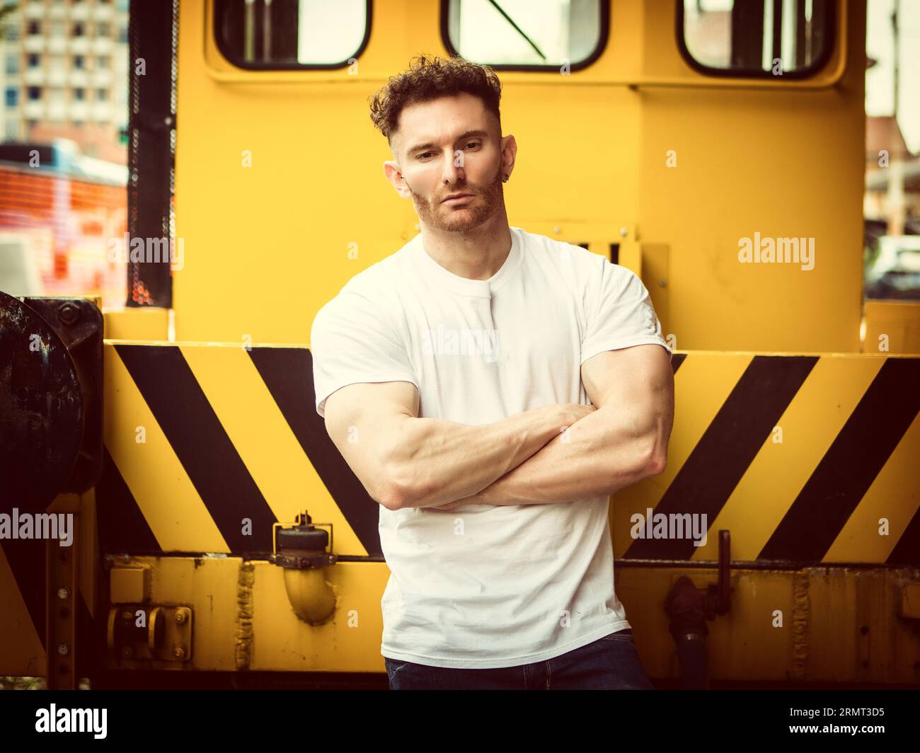 Ein Mann, der vor einem gelben Zug steht Stockfoto