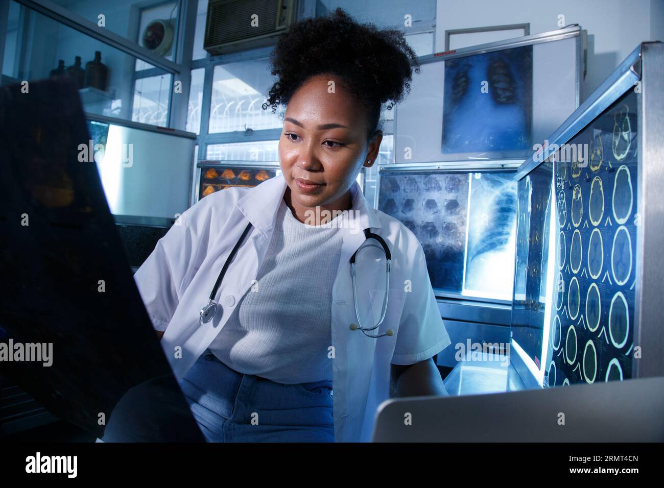 Medizinische Radiologin-Ärztin schaut Kopf- und Hirnröntgenfilm vor der Operation in der Laborpraxis des Krankenhauses. Gesundheitswesen und Bildung. Stockfoto