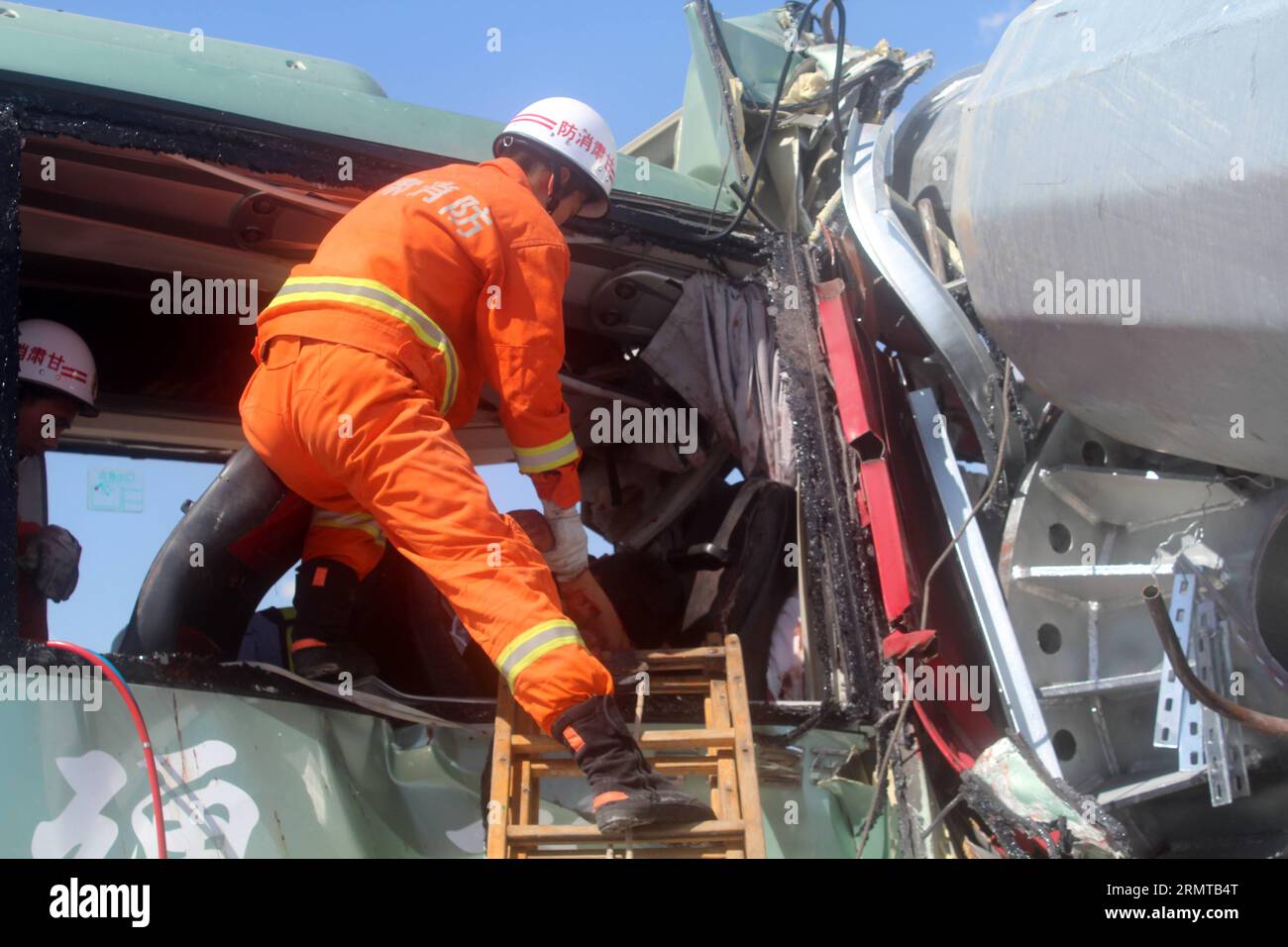 (140826) -- LANZHOU, 26. August 2014 -- Ein Feuerwehrmann nimmt an einer Rettungsaktion an dem Ort Teil, an dem ein Bus frontal mit einem Lkw auf einer Autobahn in Guazhou County in der Stadt Jiuquan, nordwestchinesische Provinz Gansu, am 26. August 2014 kollidierte. Bei dem Unfall am Dienstagnachmittag sind 13 Menschen ums Leben gekommen. Der Unfall ereignete sich gegen 12:20 Uhr, als der Bus durch die zentrale Trennwand brach und in die gegenüberliegende Spur fuhr, um auf dem entgegenkommenden Sattelzug auf der Autobahn zu landen. Die Anzahl der Verletzten wird noch überprüft. ) (HDT) CHINA-GANSU-BUS-TRUCK CRASH (CN) GAOXMING PUBLICAT Stockfoto