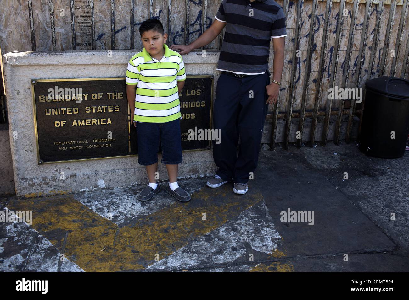 TIJUANA, 27. August 2014 -- Franco (L), der Sohn von Victor Manuel Ledezma, wartet auf den Anwalt seines Vaters, im Internationalen Hafen von San Ysidro, in der Stadt Tijuana, an der Grenze zu den Vereinigten Staaten, Nordwest-Mexiko, am 27. August 2014. Victor Manuel, der vor fünf Jahren die Vereinigten Staaten verließ, ohne wegen eines Familienproblems deportiert zu werden, und der seitdem nicht mehr in die Vereinigten Staaten zurückgekehrt ist, beantragt jetzt eine humanitäre Bewährung bei seiner Familie, insbesondere seinem Sohn Franco, der an schweren psykologischen Problemen leidet, die durch die Trennung seiner Familie verursacht werden. Guillermo Stockfoto