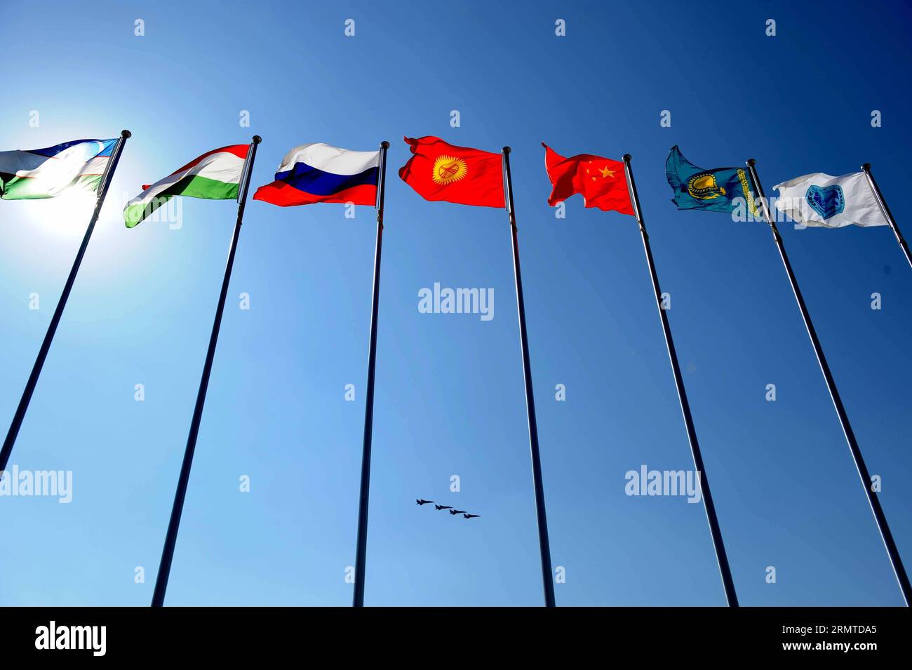 (140829) -- ZHURIHE, 29. August 2014 -- Flugzeuge fliegen während der Abschlusszeremonie der Friedensmission 2014 in Zhurihe, Innere Mongolei, Nordchina, 29. August 2014 über Flaggen von Mitgliedsländern der Shanghai Cooperation Organization (SCO). Die Übung, an der mehr als 7.000 Mitarbeiter aus China, Russland, Kasachstan, Kirgisistan und Tadschikistan beteiligt waren und die multilaterale Entscheidungsfindung verbessern, die gemeinsamen Anti-Terror-Bemühungen schärfen und den Austausch von Geheimdiensten fördern sollte, um Frieden und Stabilität in der Region zu gewährleisten, endete hier am Freitag zusammen mit der ersten Ausgabe des militärischen Tattoos der SCO. ) CHINA-INNERE MONGOLEI Stockfoto