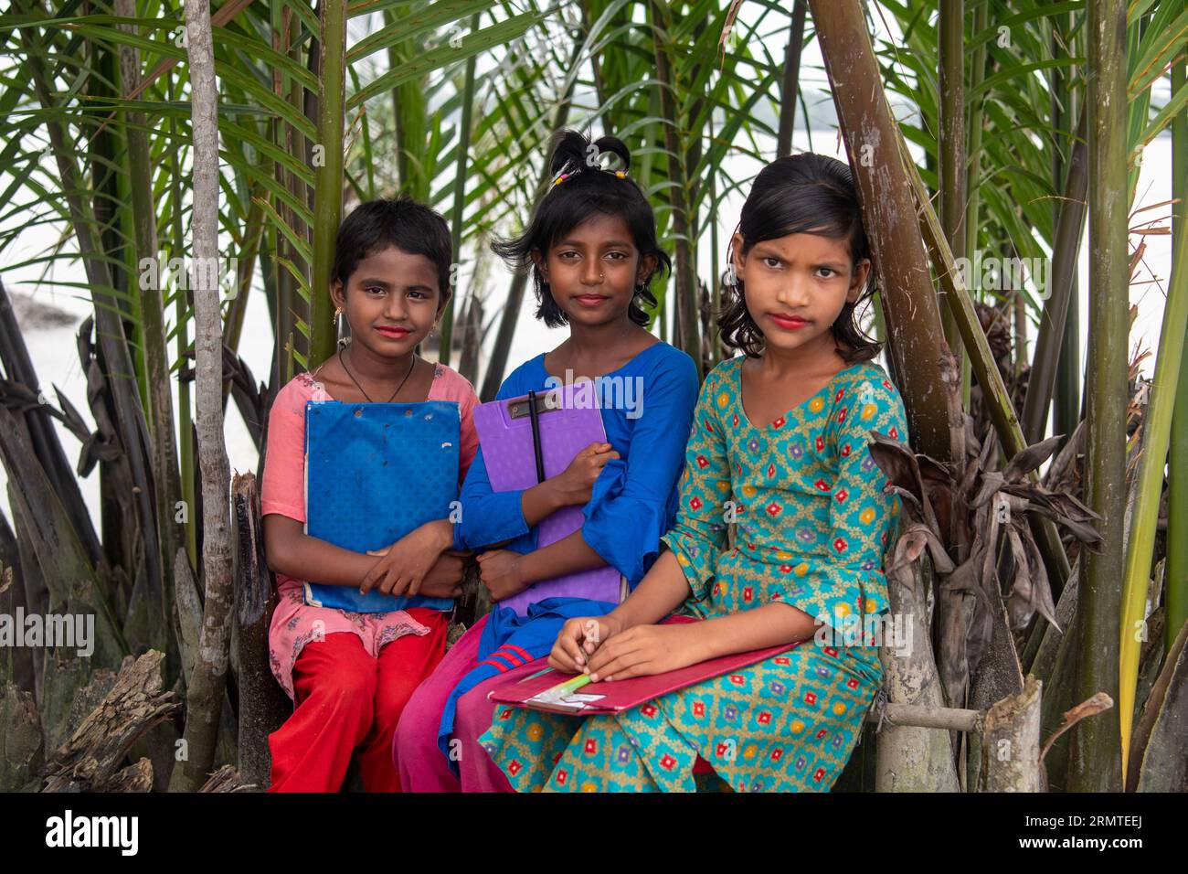 27. August 2023, Khulna, Bangladesch: Majia Akhtar (L) 9 Jahre alt Karima Begum, 10 Jahre alt (M) Sariya Akhtar, 11 Jahre alt posiert für ein Foto auf dem Weg zur Schule in einem Küstengebiet von Kalabogi in Khulna. Vor nicht allzu langer Zeit war Kalabogi, ein Küstendorf in Bangladesch, voll von kultivierbarem Land, bis der Anstieg des Meeresspiegels begann, das Gebiet bis zur Bucht von Bengalen zu verschlingen. Häufige Zyklone und Überschwemmungen haben das Dorf seit den späten 1990er Jahren getroffen 2009 zerstörte ein großer Zyklon namens Aila die 1.400 Kilometer Dämme, 8.800 Kilometer Straßen und etwa 50.000 acr Stockfoto