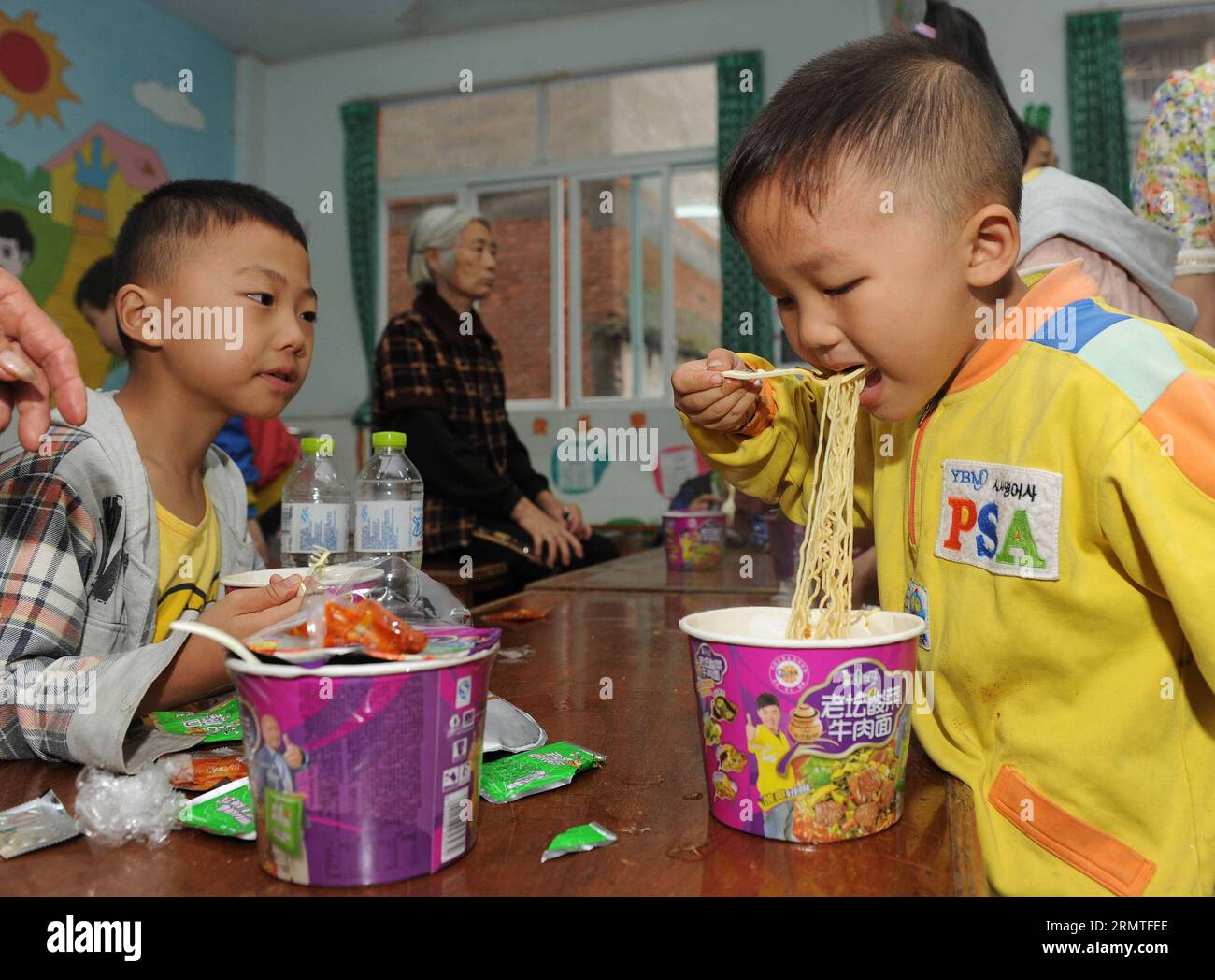 (140902) -CHONGQING, 2. September 2014 -- der vierjährige Jin Shui an (R) frühstückt in einem Tierheim, nachdem er aus einer regengeplagten Gemeinde im Yunyang County, südwestchinesische Gemeinde Chongqing, am 2. September 2014 evakuiert wurde. Acht Menschen starben und 24 weitere wurden Anfang Dienstag vermisst, nachdem Regenfälle Erdrutsche nach Chongqing brachten, sagte das örtliche Rettungszentrum. Mehr als 500 professionelle Rettungskräfte haben über 7.000 Bewohner in neun regennassen Townships im Yunyang County an sichere Orte evakuiert, sagte das Hauptquartier. (wf) CHINA-CHONGQING-RAININSTORM (CN) ChenxCheng PUBLICATIONxNOT Stockfoto