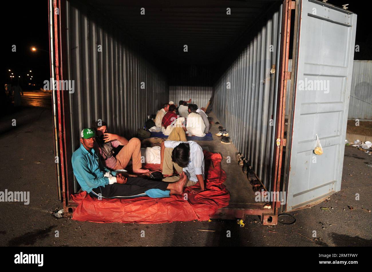 (140903) -- ISLAMABAD, -- Unterstützer des pakistanischen Tehrik-e-Insaf-Führers Imran Khan und des religiösen Führers Tahir-ul-Qadri ruhen während eines regierungsfeindlichen Protestes in der Nähe des Wohnsitzes des Premierministers in Islamabad, der Hauptstadt Pakistans, am 2. September 2014 in einem Container. Hochrangige politische Führer in Pakistan haben am Dienstag Premierminister Nawaz Sharif ins Visier genommen und zwei Oppositionsführer verurteilt, weil sie gegen die Regierung protestiert haben, die das Leben in der Hauptstadt Islamabad gestört hat. ) PAKISTAN-ISLAMABAD-PROTEST-KHAN AhmadxKamal PUBLICATIONxNOTxINxCHN Islamabad-Unterstützer von Pakistan Teh Stockfoto