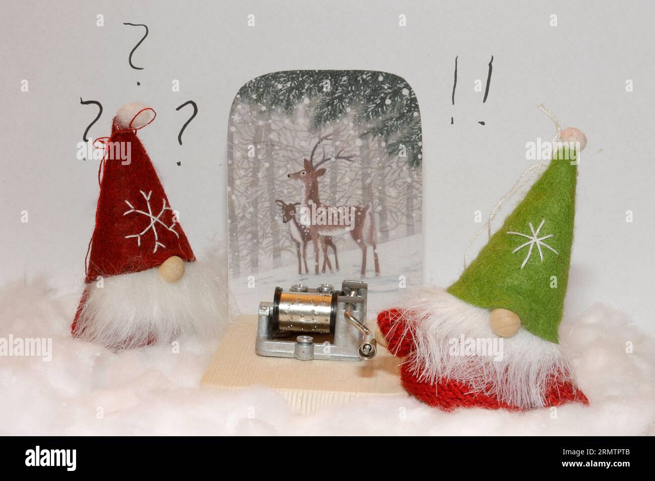 Zwei weihnachtselfen finden ein Carillon auf dem Schnee, die auf der rechten Seite versucht es zu drehen. Verspielter Stil, Schnee aus Baumwolle. Stockfoto