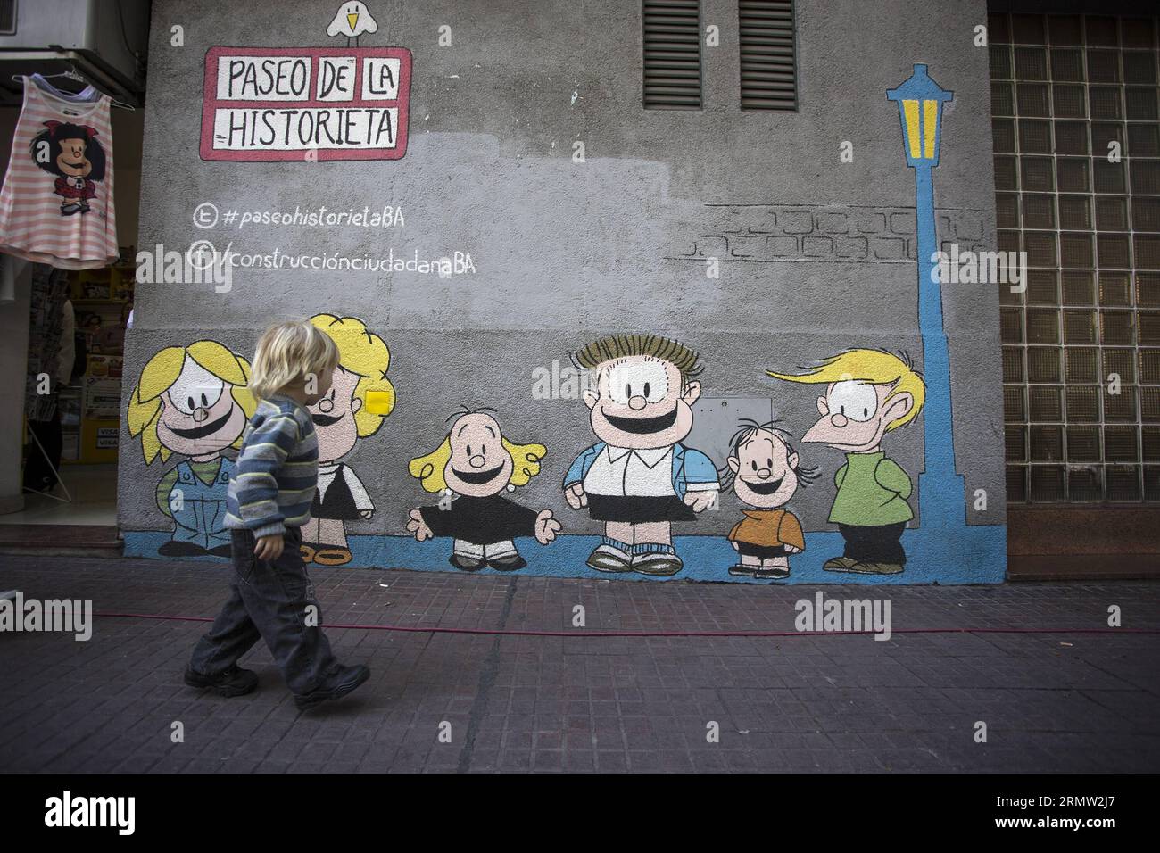 Ein Kind beobachtet die Zeichnung von Mafaldas Freunden, die auf dem Gebäude gemalt wurden, wo die Figur während des 50. Jahrestages der ersten Veröffentlichung von Mafalda auf dem Cartoon Walk in Buenos Aires, Argentinien, am 29. September 2014 entstand. Mafalda, die Figur des Karikaturisten Joaquin Salvador LAVADO, besser bekannt als Quino, hatte am Montag ihren 50-jährigen Geburtstag. Es wurde in 30 Sprachen auf der ganzen Welt veröffentlicht.Martin Zabala vfda ARGENTINA-BUENOS AIRES-CULTURE-MAFALDA e MARTINXZABALA PUBLICATIONxNOTxINxCHN Stockfoto