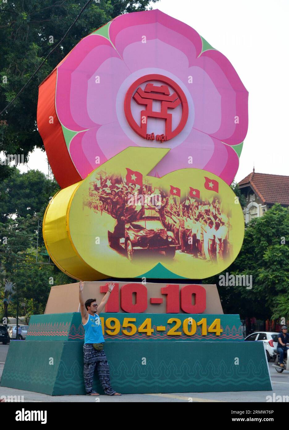 (141009) -- HANOI, 9. Oktober 2014 -- Ein Mann posiert mit einem Symbol, das anlässlich des 60. Jahrestages der Befreiung der Stadt in Hanoi, der Hauptstadt Vietnams, 9. Oktober 2014 gebaut wurde. Die Stadt feierte ihren 60. Jahrestag der Befreiung von der französischen Kolonialherrschaft, der auf den 10. Oktober fällt. VIETNAM-HANOI-LIBERATION-60th ANNIVERSARY-CELEBRATION YanxJianhua PUBLICATIONxNOTxINxCHN Hanoi OKT 9 2014 ein Mann posiert mit einem Symbol, das gebaut wurde, um den 60. Jahrestag der Befreiung der Stadt in Hanoi Hauptstadt von Vietnam OKT 9 2014 die Stadt zu feiern, was ihren 60. Jahrestag der Befreiung von Französisch-Coloni feiert Stockfoto