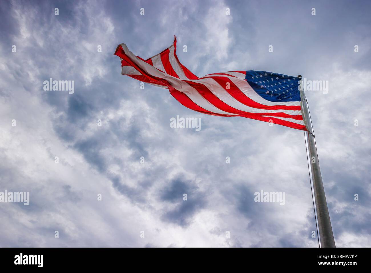 Die amerikanische Flagge fliegt unter wolkenverhangenen Sies auf dem Gipfel des Chimney Rock im Chimney Rock State Park in North Carolina. Stockfoto