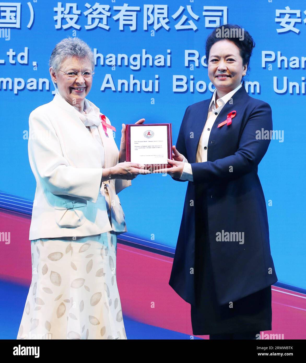 Peng Liyuan (R), eine Botschafterin der Weltgesundheitsorganisation (WHO) für Tuberkulose und HIV/AIDS, verleiht der französischen Wissenschaftlerin Francoise Barre-Sinoussi, Nobelpreisträgerin für Physiologie oder Medizin, eine Medaille für die Mitentdeckung von HIV, während der Eröffnungszeremonie der Nationalen Konferenz über HIV/Aids 2014 in Peking, Hauptstadt Chinas, 20. Oktober 2014. ) (wf) CHINA-BEIJING-PENG LIYUAN-HIV/AIDS-KONFERENZ (CN) YaoxDawei PUBLICATIONxNOTxINxCHN der chinesische Präsident Xi Jinping S Ehefrau Peng Liyuan r, die eine Weltgesundheitsorganisation IST, IST S Goodwill Ambass Stockfoto