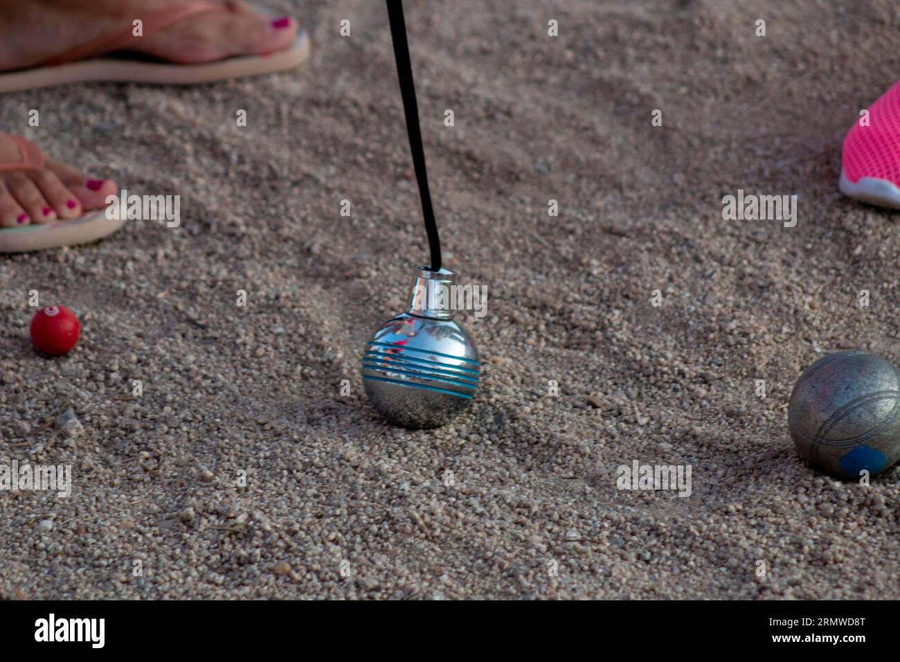 Petanque-Spiel. Sie können die Stahlkugeln in verschiedenen Farben und den Magneten sehen, mit dem sie gesammelt werden. Stockfoto