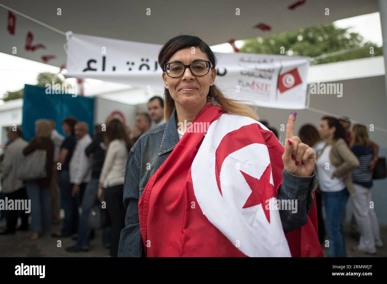 Eine tunesische Wählerin, die die Abstimmung beendet hat, zeigt am 26. Oktober 2014 vor einem Wahllokal in Tunis, der Hauptstadt Tunesiens, ihren mit Tinte gefärbten Finger. Tunesier gingen am Sonntag zur Wahl, um die 217 Mitglieder des ersten gewählten parlaments seit dem Bürgeraufstand 2011 auszuwählen. TUNESIEN-TUNIS-PARLAMENTSWAHLEN-ABSTIMMUNG PanxChaoyue PUBLICATIONxNOTxINxCHN eine TUNESIERIN, die ihre Stimme beendet, zeigt ihre mit Tinte gefärbten Finger vor einer Wahlstation in Tunis, der Hauptstadt Tunesiens, AM 26 2014. Oktober, ging zu den Wahlen AM Sonntag, um die 217 Mitglieder des ersten gewählten Parlaments seit dem Bürgerlichen Uprisin zu wählen Stockfoto