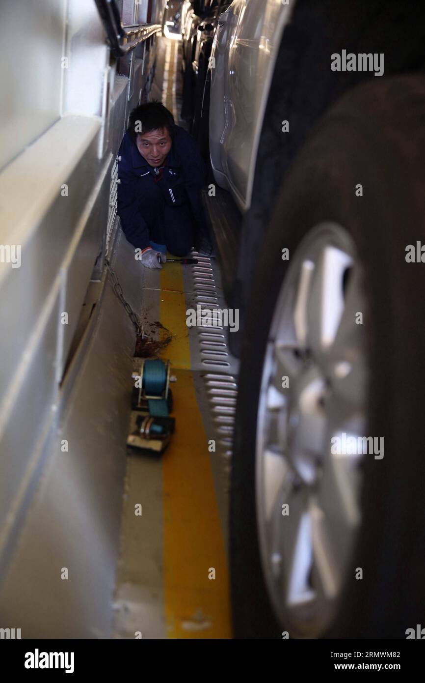 (141104) -- PEKING, 4. November 2014 -- Ein Arbeiter fixiert Ein Auto auf eine Kutsche am Bahnhof Dahongmen in Peking, Hauptstadt von China, 4. November 2014. Das Beijing Railway Bureau hat während der Feiertage der Asia-Pacific Economic Cooperation (APEC) Economic Leaders Week, die vom 5. Bis 11. November in Peking stattfinden wird, mehrere spezielle Zugverbindungen für selbstfahrende Touristen eröffnet. ) (Zkr) (APEC2014)CHINA-BEIJING-SELF-DRIVING-SPECIAL TRAINS (CN) JinxLiwang PUBLICATIONxNOTxINxCHN Peking 4. November 2014 A Worker fixiert AM 4. November 2014 ein Auto auf eine Kutsche AM Bahnhof Dahongmen in der chinesischen Hauptstadt Peking Stockfoto