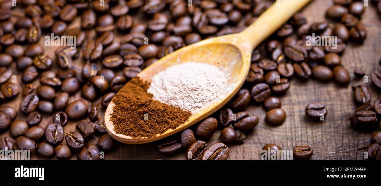 Löffel mit Pulver und Kaffeebohnen auf altem Holzlöffel Stockfoto