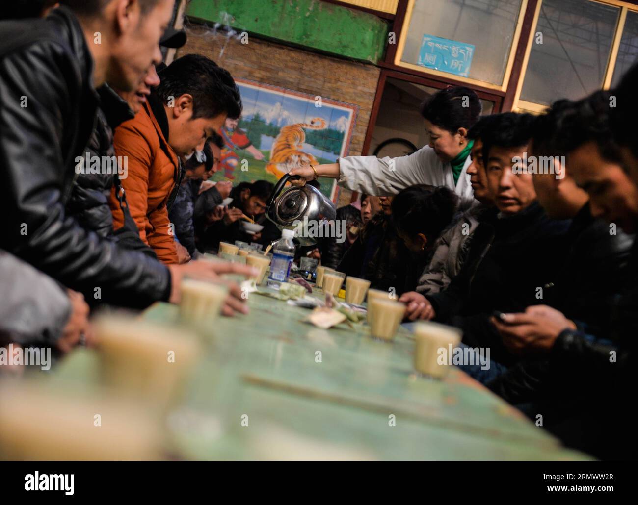 (141111) -- LHASA, 11. November 2014 -- Eine Kellnerin füllt Tassen mit süßem Tee in einem Teehaus namens Guangminggangqiong in Lhasa, Hauptstadt der autonomen Region Tibet im Südwesten Chinas, 7. November 2014. Der süße Tee ist eine beliebte Art und Weise für Menschen, die in Lhasa leben oder bleiben, um ihre Freizeit zu verbringen. ) CHINA-TIBET-LHASA-TEEHAUS-SÜSSER TEE (CN) PurbuxZhaxi PUBLICATIONxNOTxINxCHN Lhasa 11. November 2014 eine Kellnerin füllt Tassen mit SÜSSEM Tee in einem TEEHAUS, das in Lhasa, Hauptstadt Südwestchinas, der autonomen Region Tibet, genannt WIRD. November 2014 Stockfoto