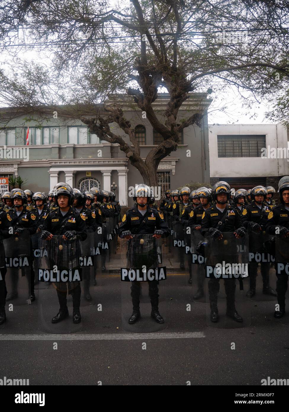 Lima, Peru - Juli 29 2023: Peruanische Männer in schwarzer Kleidung und Helmen tragen beim Unabhängigkeitstag eine Waffe und ein Schild mit der Aufschrift „Polizei“ Stockfoto