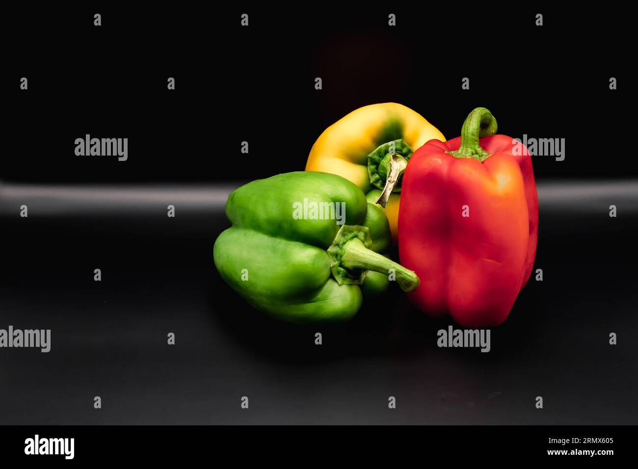 Verschiedenfarbige Paprika auf schwarzem Hintergrund Stockfoto