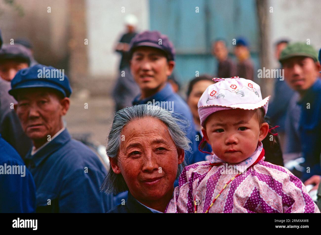China. Qinghai. Xining. Einheimische Frau und Kind in überfüllten Straßen. 1980er Jahre Stockfoto