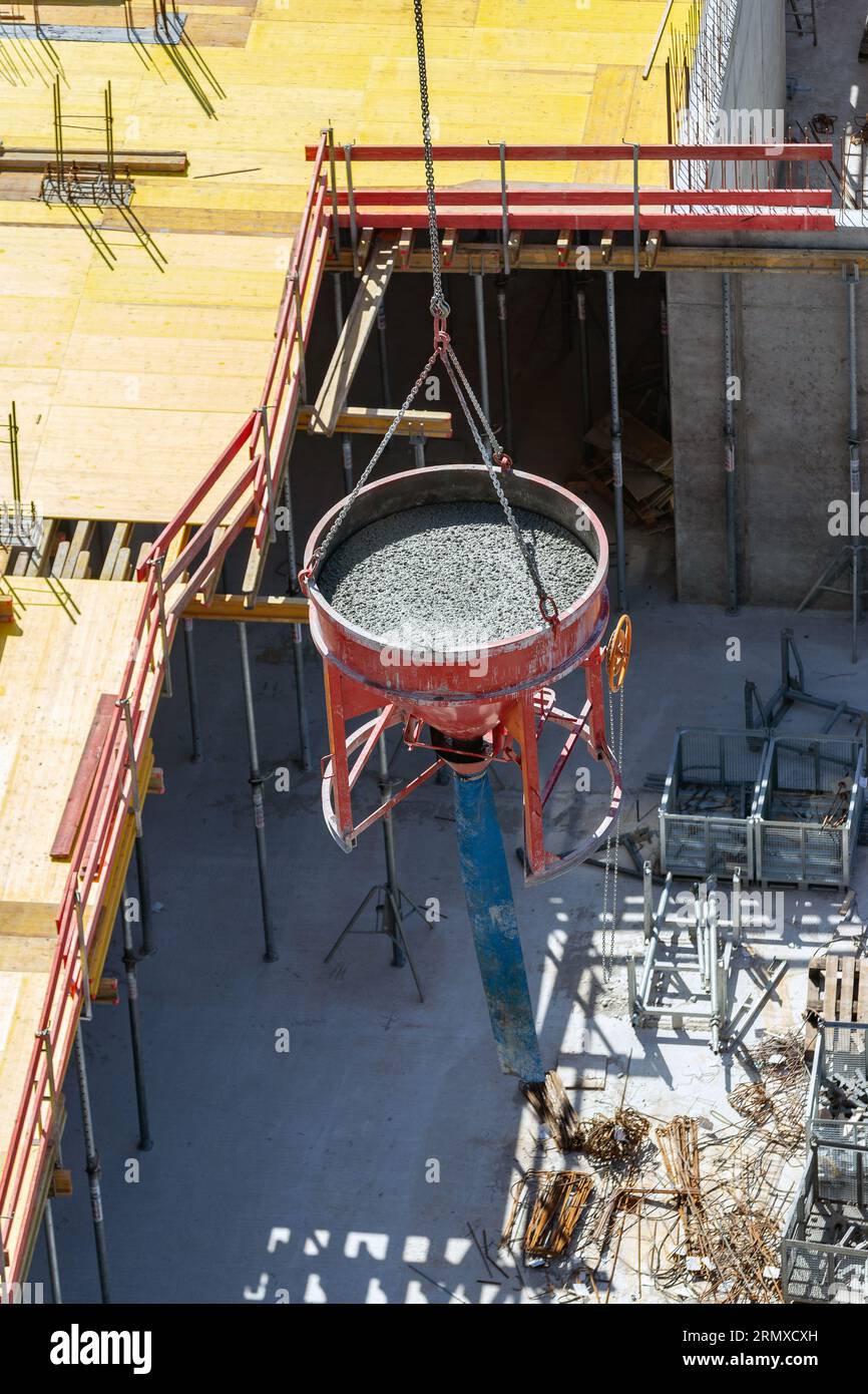 Stahltrichter mit frischem Beton über der Baustelle Stockfoto