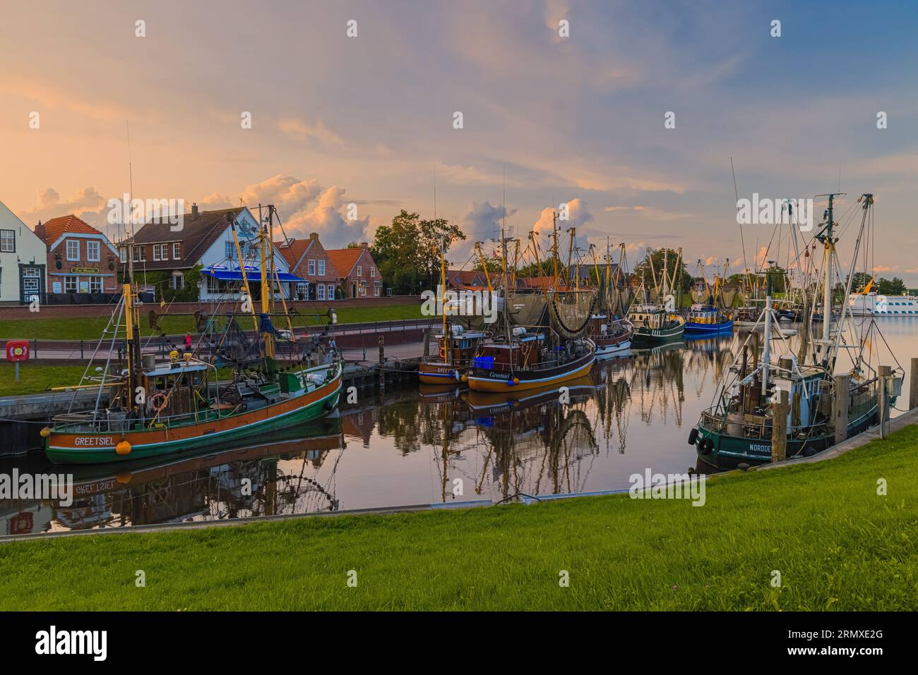 Ein abendliches Foto des malerischen Hafens im Fischerdorf Greetsiel. Greetsiel ist eine kleine Hafenstadt an der Leybocht im Westen von East F Stockfoto