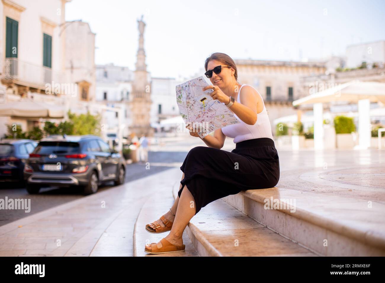 Weibliche Touristen mit einem Stadtplan von der Statue des Heiligen Oronzo in Ostuni, Italien Stockfoto