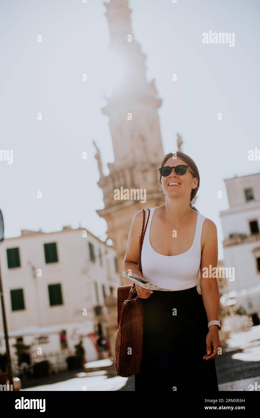 Weibliche Touristen mit einem Stadtplan von der Statue des Heiligen Oronzo in Ostuni, Italien Stockfoto