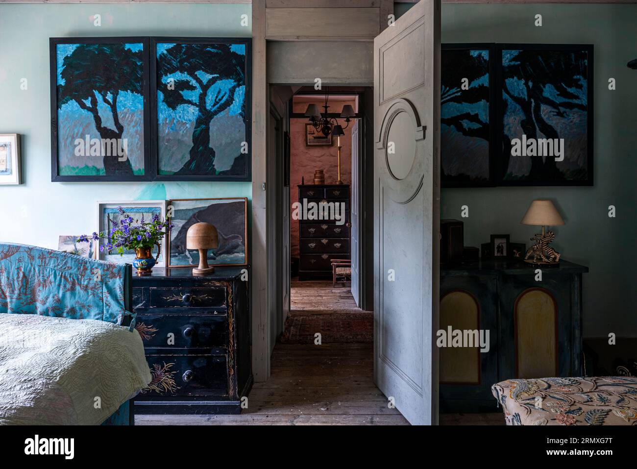 Dramatische Kunstwerke mit Blick durch die offene Tür aus dem Schlafzimmer des aus dem 18. Jahrhundert stammenden Blumenlofts in der Nähe von Penzance in Cornwall, Großbritannien Stockfoto