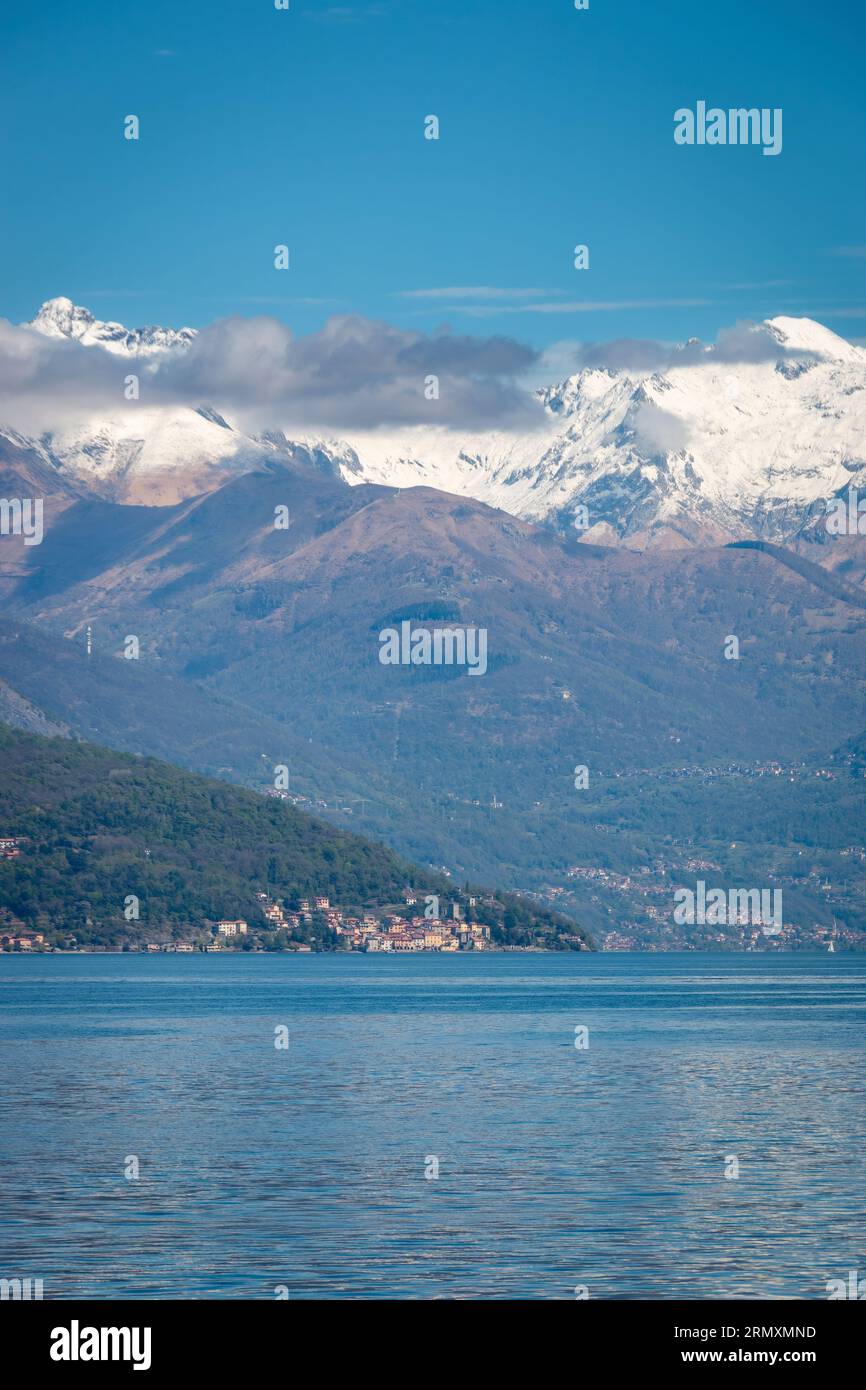 Malerischer Blick auf den Comer See, Italien und seinen nördlichen Zweig mit Blick nach Norden mit Santa Maria Rezzonico und schneebedeckten Bergen im Hintergrund vor bl Stockfoto