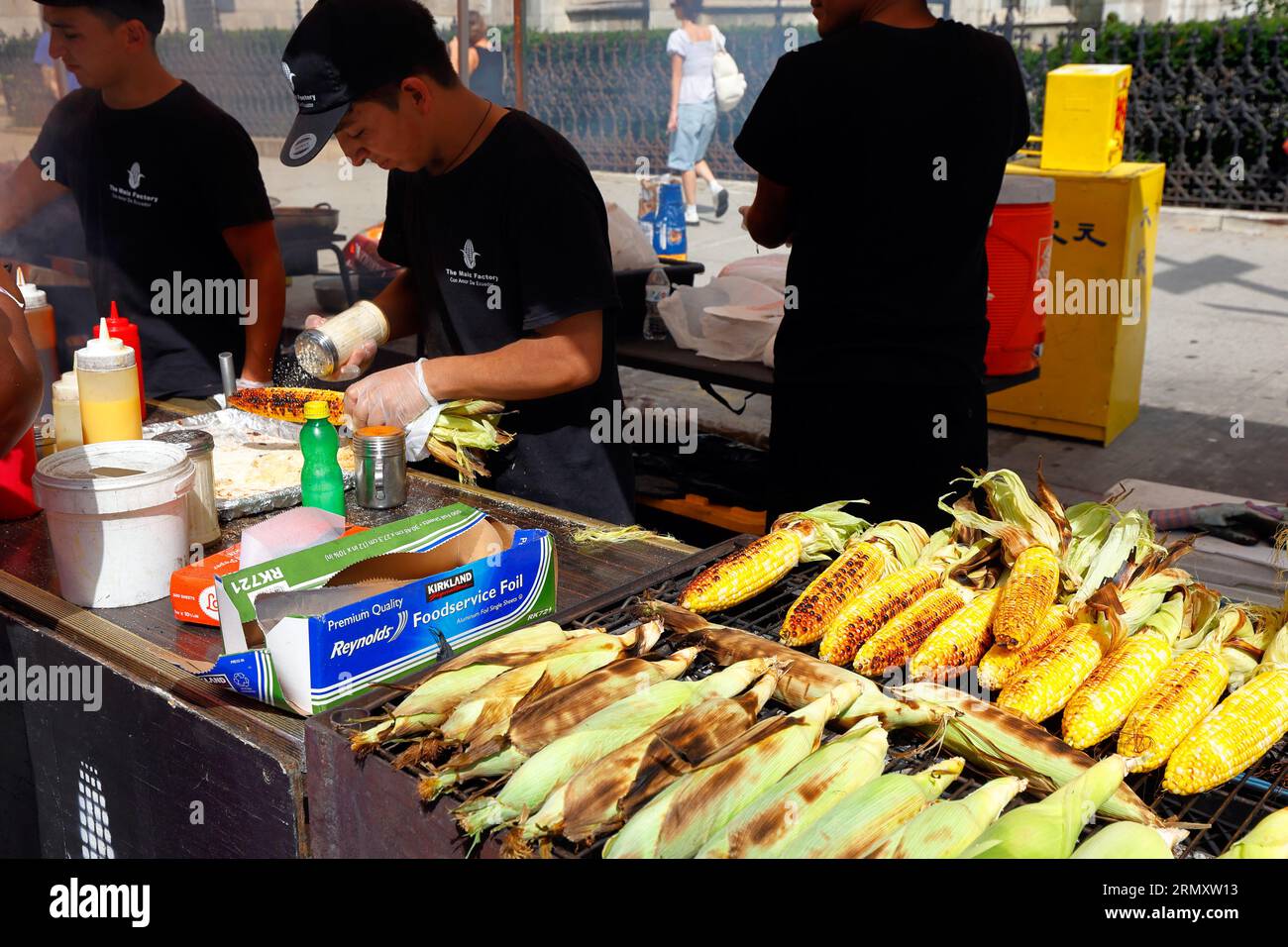 Die Maiz Factory Con Amor de Ecuador-Mitarbeiterin bereitet auf einer Straßenmesse in New York City, 26. August 2023, gegrillten Mais vom Choclo Asado, Elote, auf dem Maiskolben zu Stockfoto