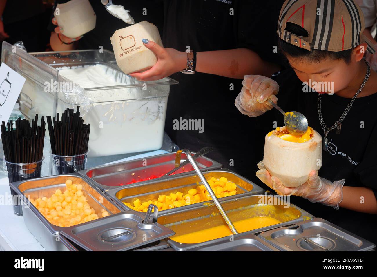 好椰 Ja Coconut Staff Löffel Mango Toppings auf einem Kokosnussmilchpudding Dessert auf der Dragon Fes Food Festival Street Fair in NYC, 27. August 2023. Stockfoto